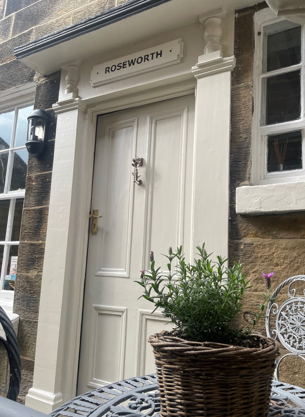The white front door and stone exterior of Roseworth Cottage