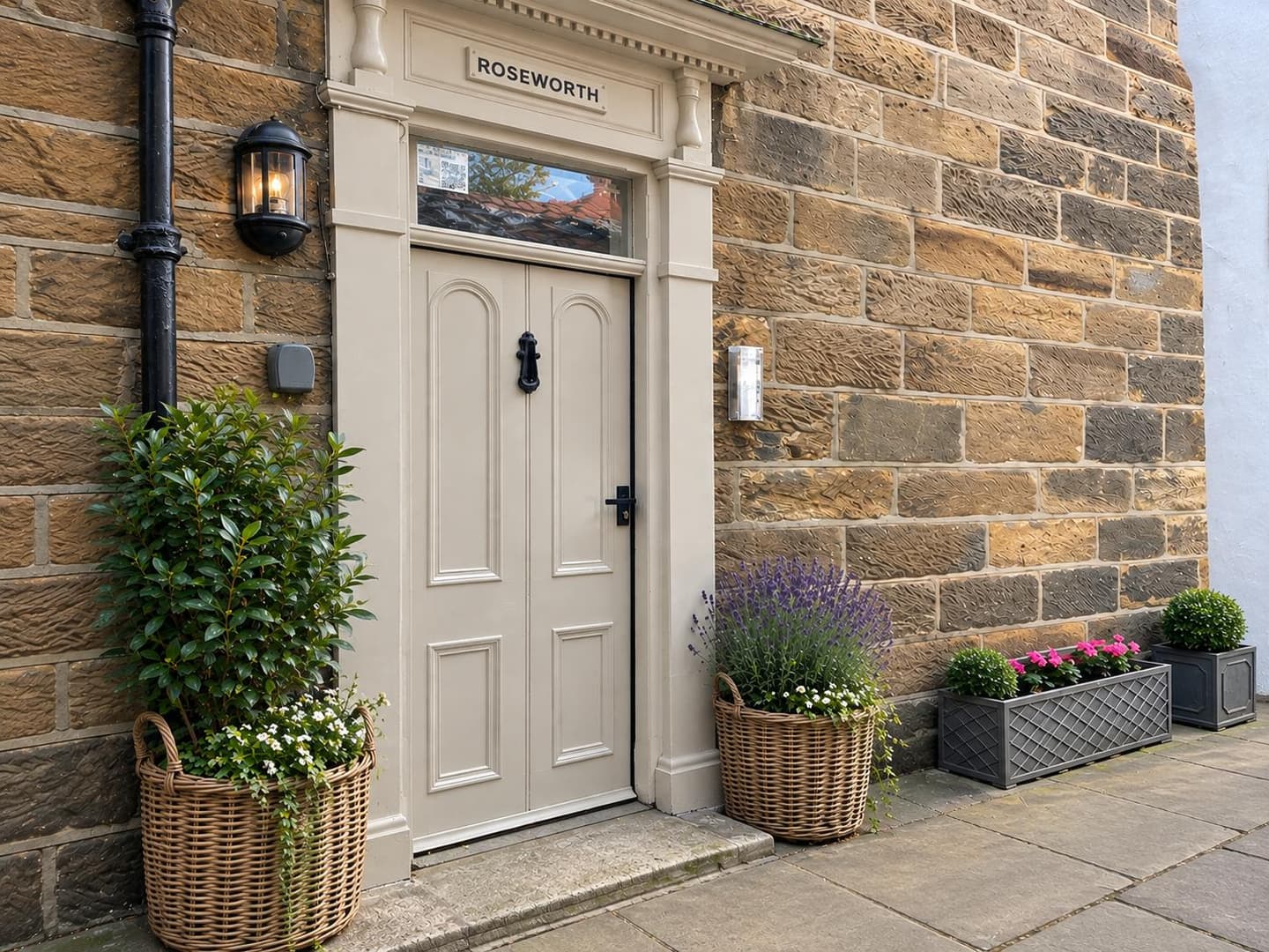 Roseworth main entrance surrounded by flowers and potted plants