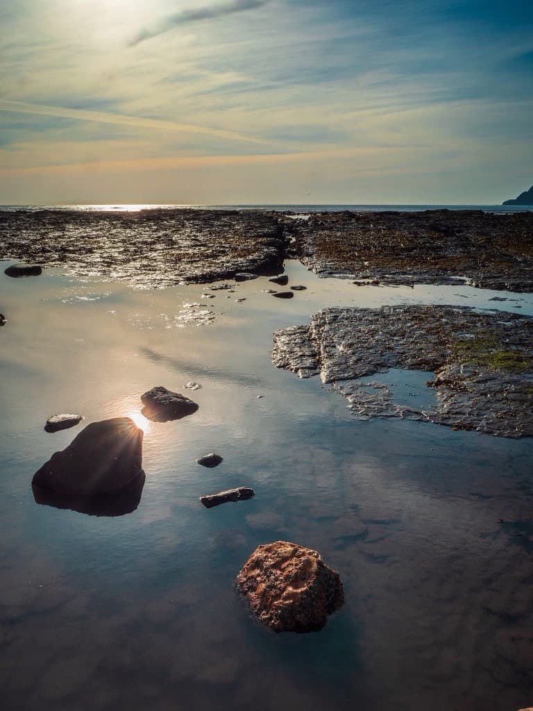 Sunlight over tidal rock pools on the beach