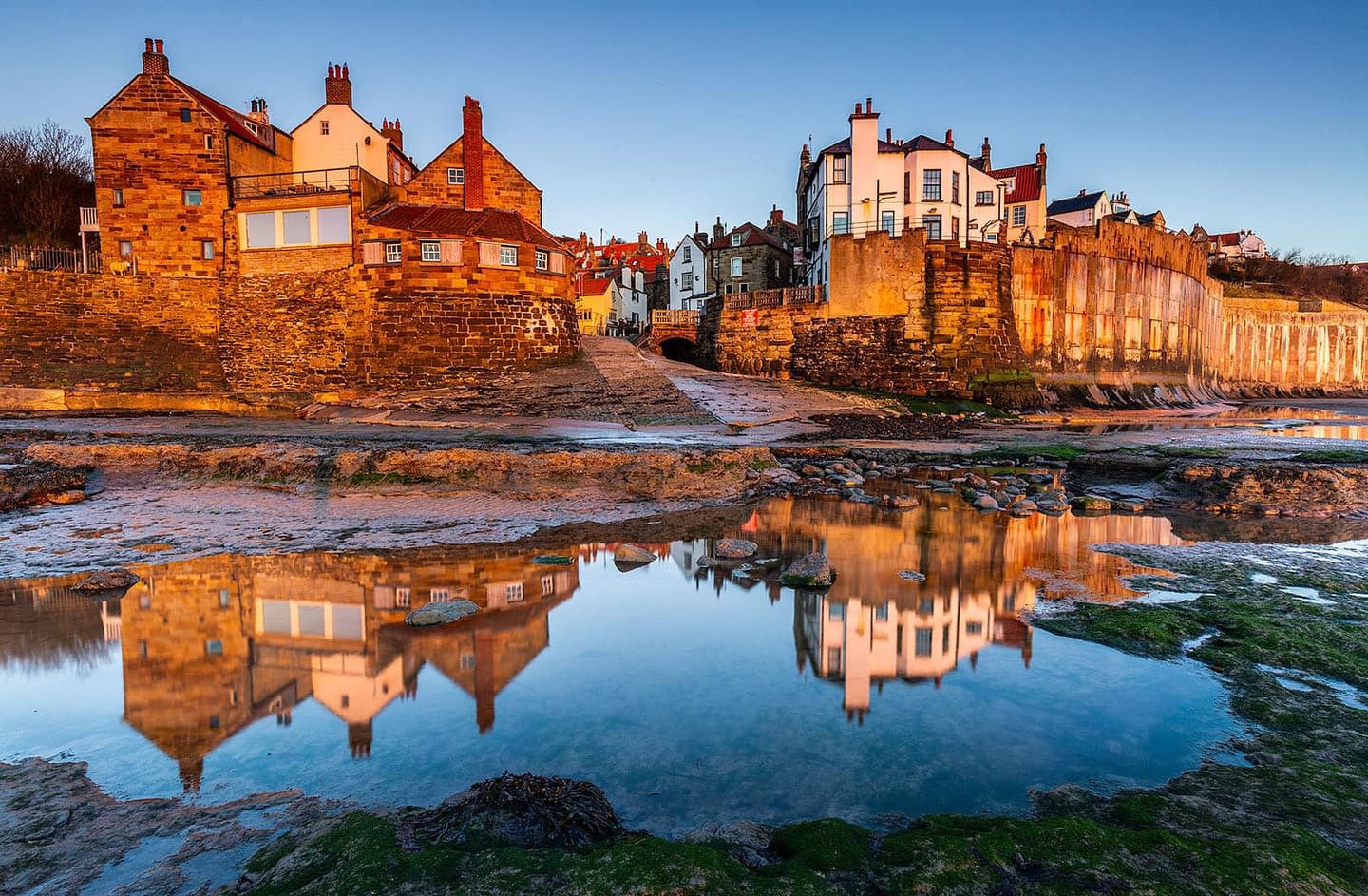 The village reflected in a rock pool at sunset