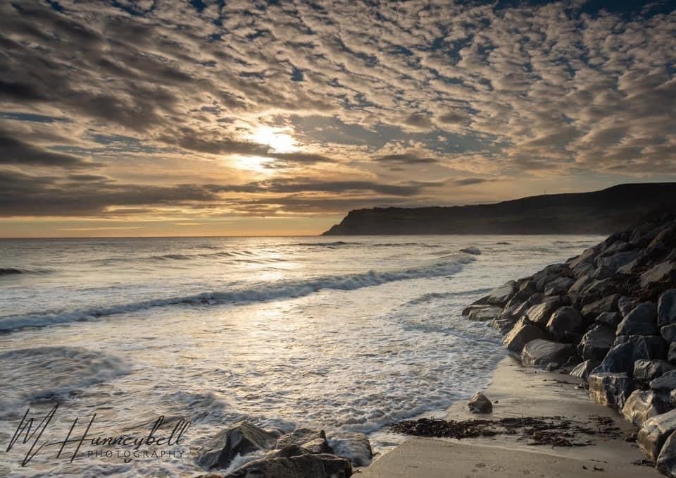 Sunlight over breaking waves and sea defences