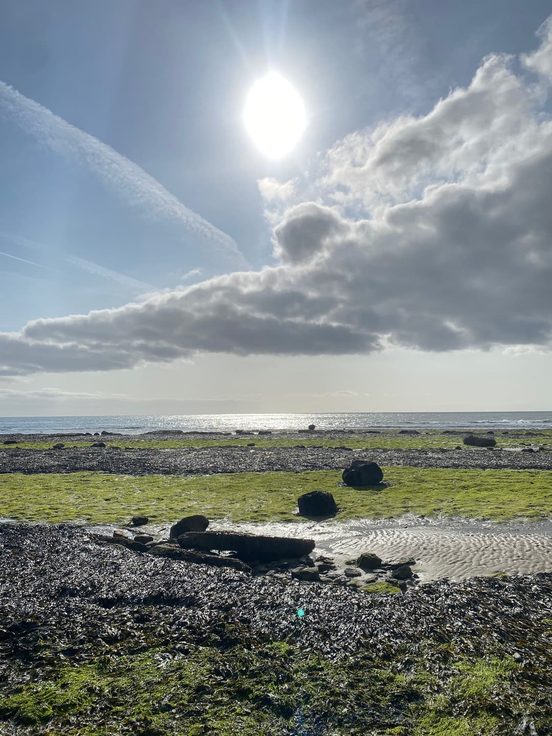 Bright sun and cloud above the rock pools