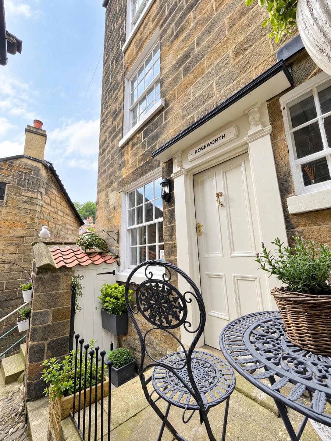 Outdoor table and chair beside the cottage entrance
