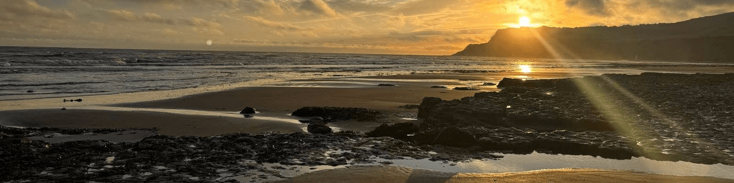 Sunset over the beach and coastline at Robin Hood’s Bay